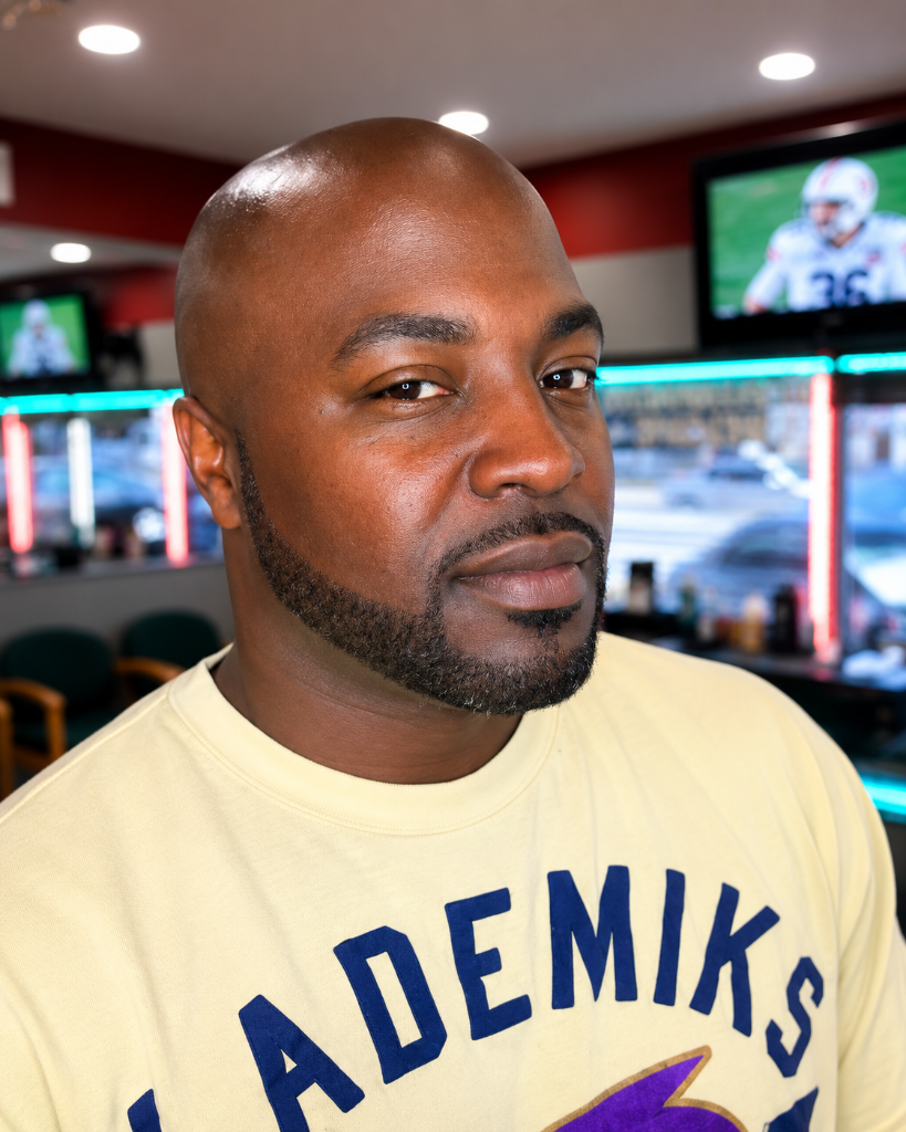 Man in yellow sweatshirt portrait in barbershop