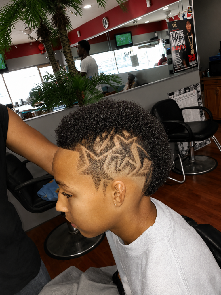 Barber giving young man a mohawk with star designs