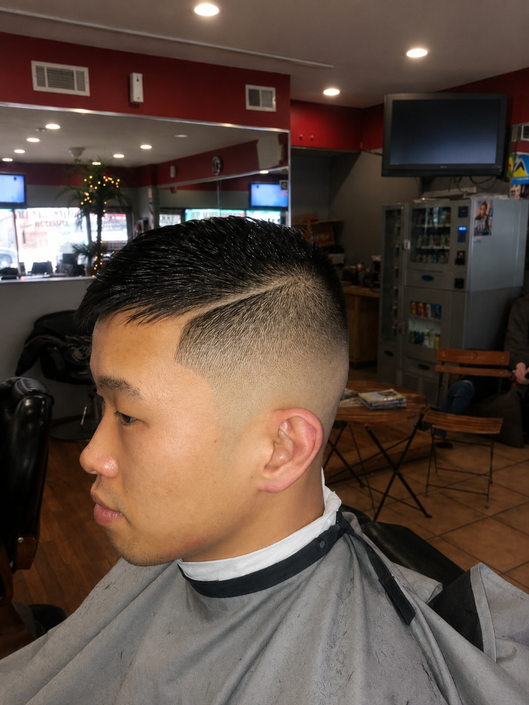 Man with fresh fade haircut in barber chair