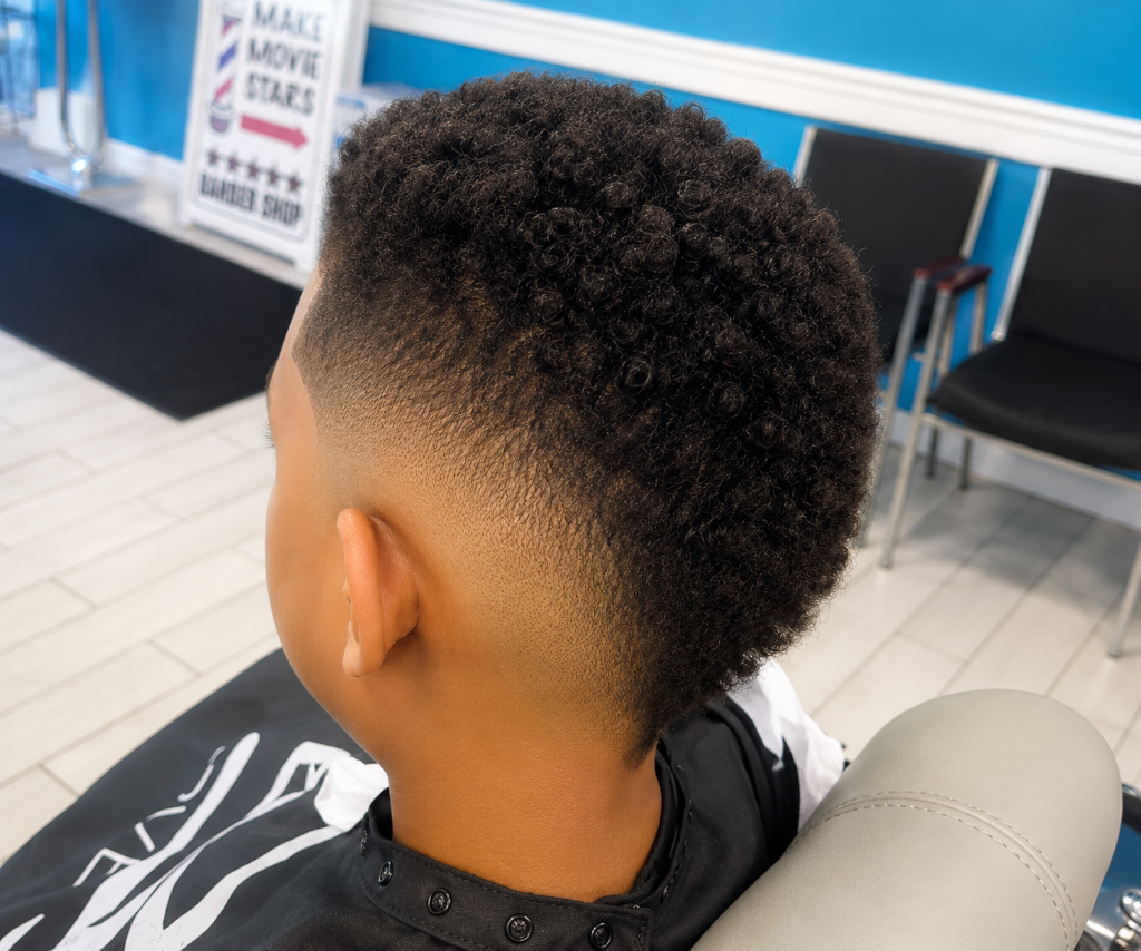 Young boy with tight curls and low fade