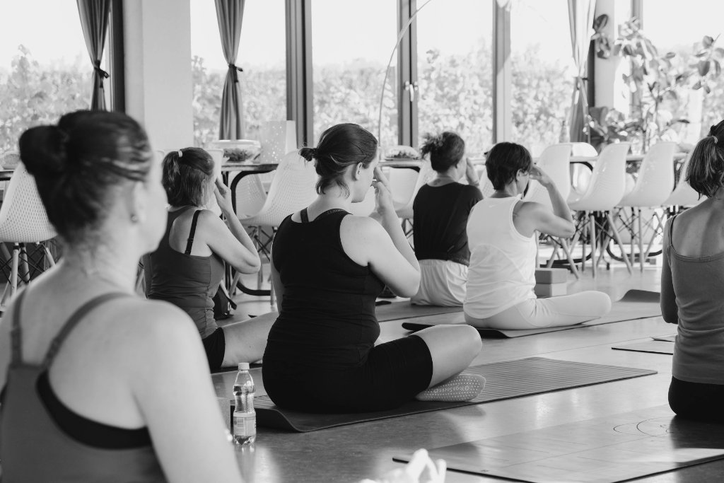 Fekete-fehér csoportos meditáció ülő pózokban