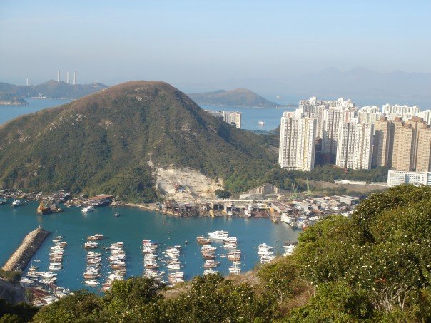 Aberdeen Harbour, Hong Kong – marina of small white boats with hills and high-rise buildings beyond