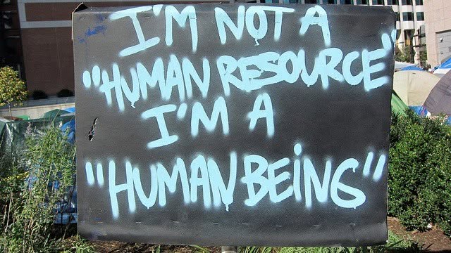 Protest sign reading: I'm not a human resource, I'm a human being