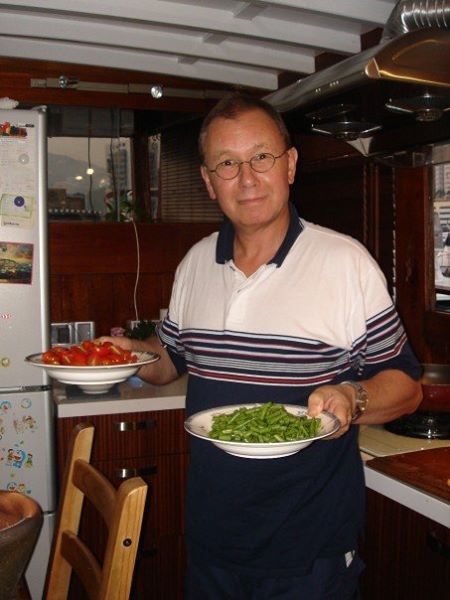 Paul Penfold in the galley of the converted junk Watermark, holding plates of fresh food