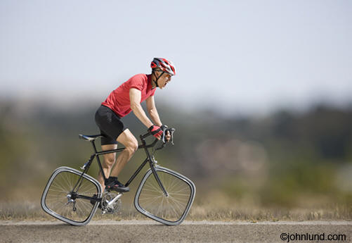 Cyclist riding a bicycle with square wheels — work smarter, not harder