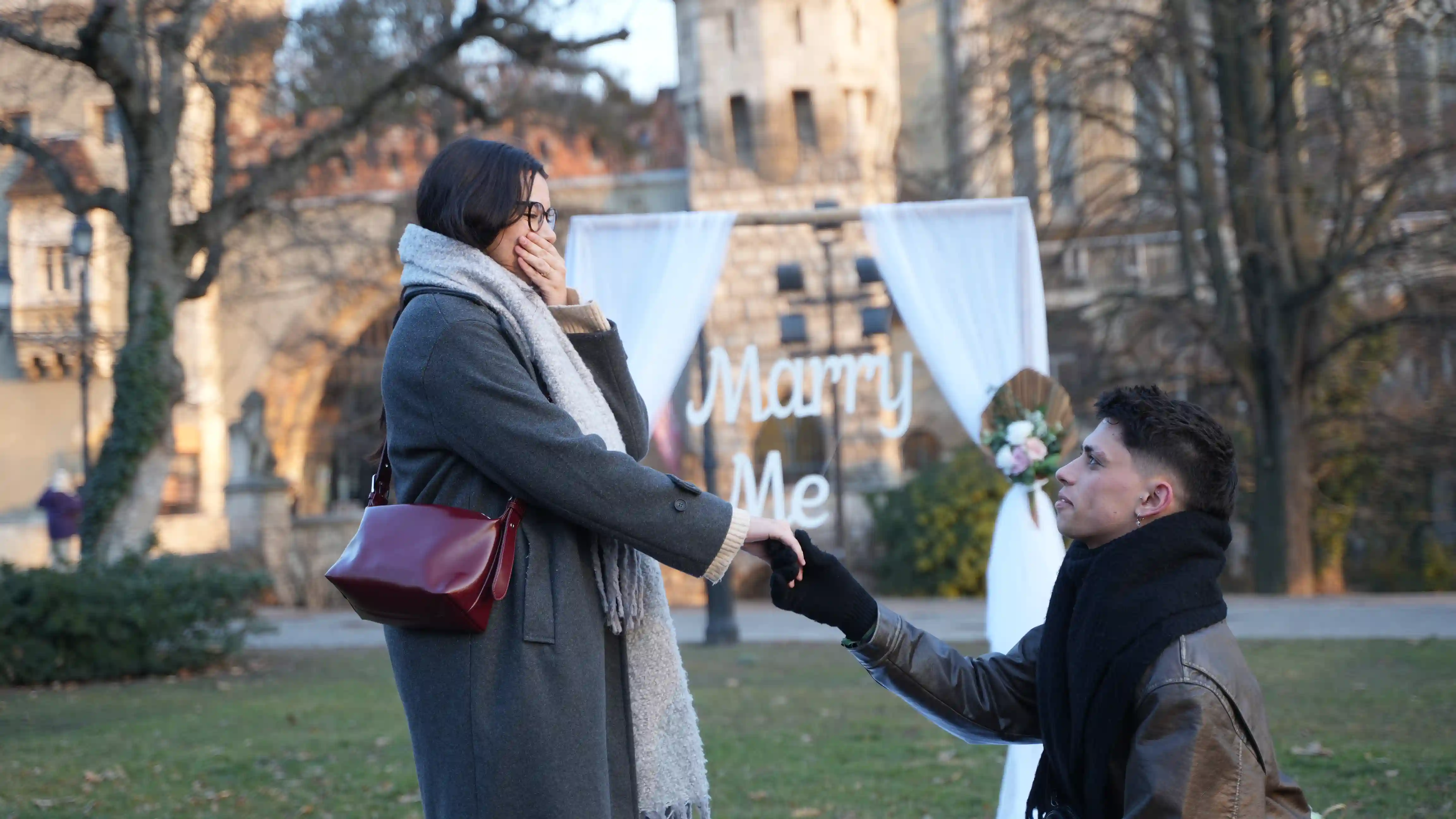 Wedding proposal Budapest — man on one knee with Marry Me arch at Vajdahunyad Castle