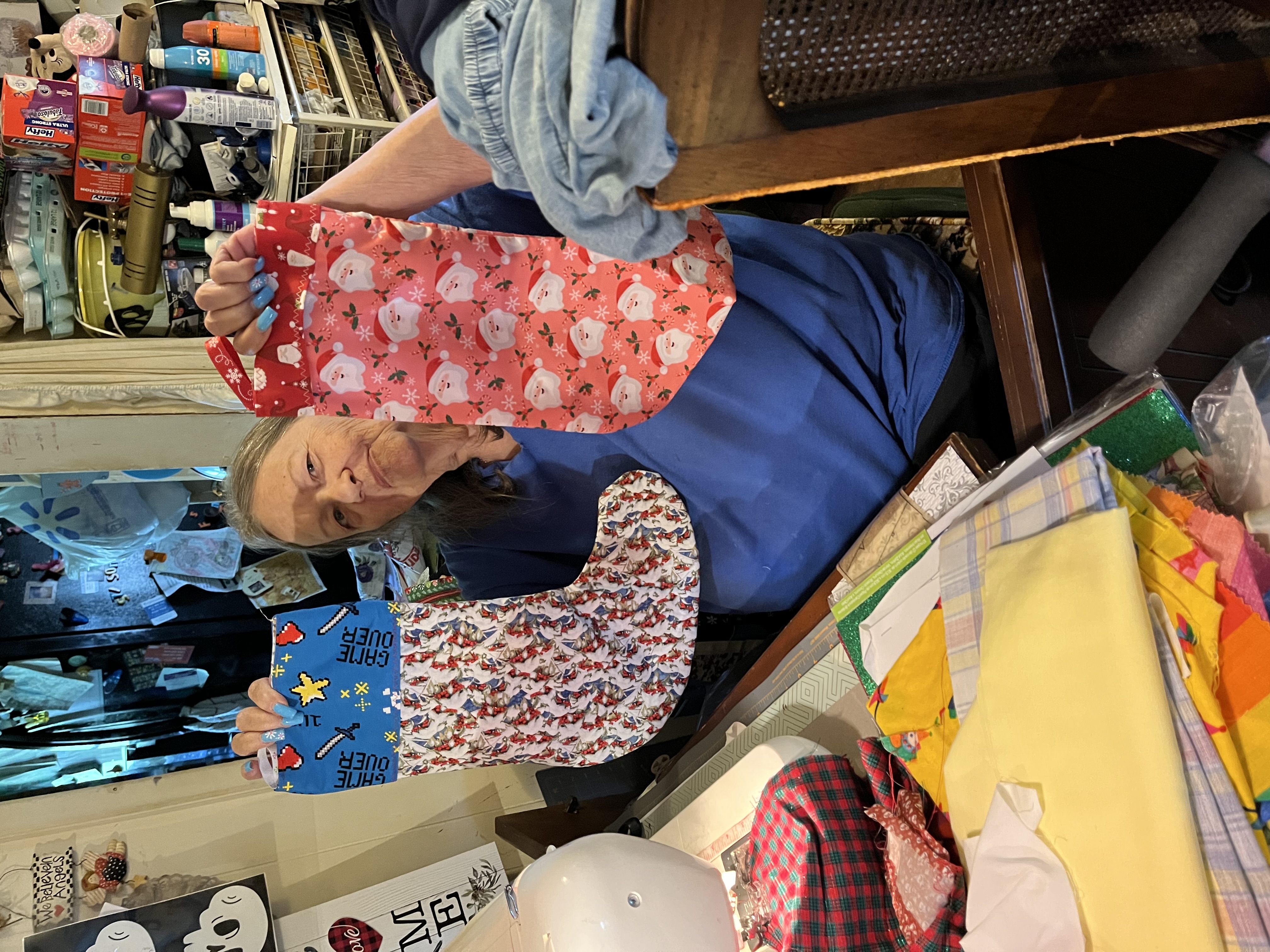 A volunteer holding up two handmade Christmas stockings
