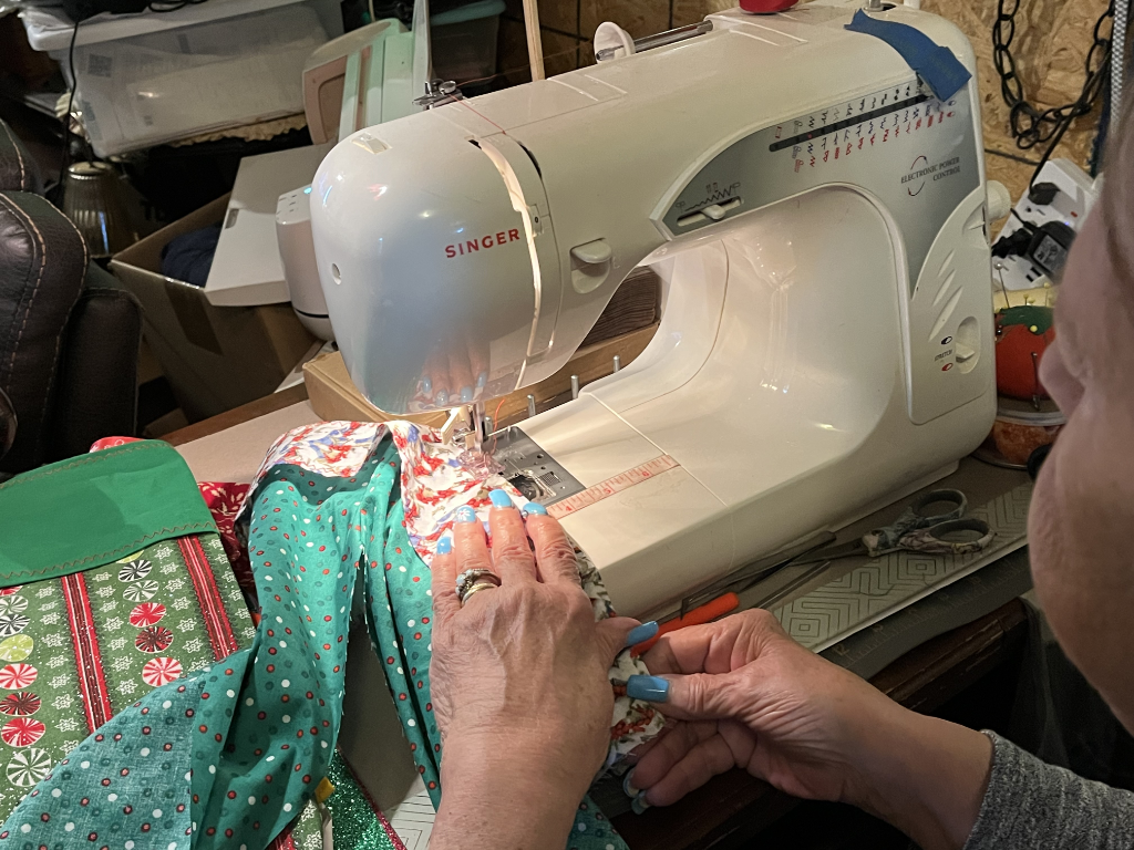 Close-up of hands sewing a Christmas stocking on a Singer machine