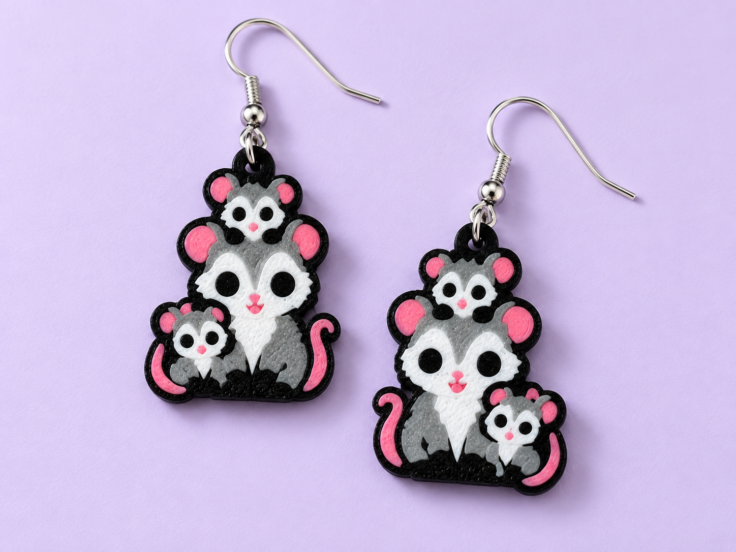Opossum earrings with a grey mama possum carrying two babies, with white faces, pink noses and black detailing