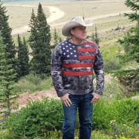 Gary, bassist for Gypsy Troubadour, in a beige cowboy hat and American flag shirt