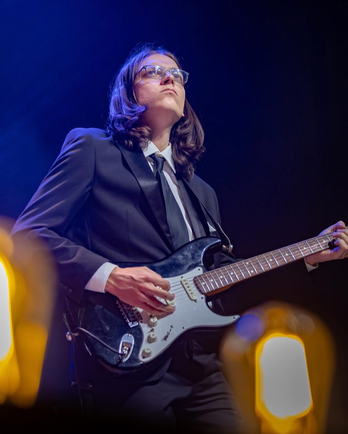 Clayton playing electric guitar on stage