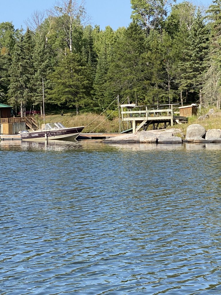 View from the water of the dock, deck, and moored boat at the point