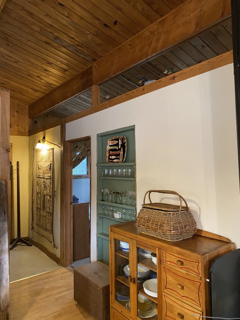 Warm wood-panelled hallway inside the cottage with a woven wall hanging