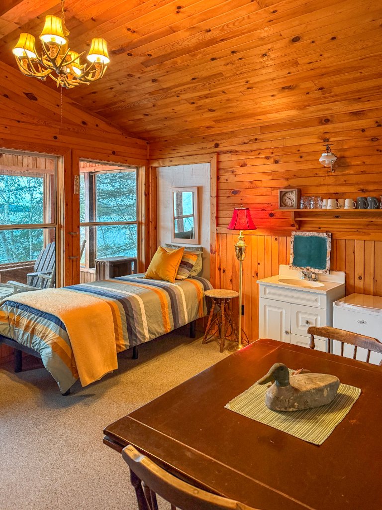 Bunky interior with two beds and a wooden table under a wood ceiling
