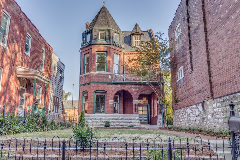 Three-story Victorian red brick home with turret and wrought iron balcony in Soulard, St. Louis, Missouri