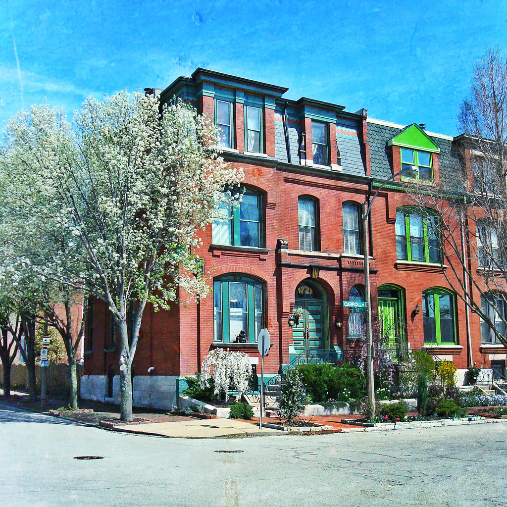 Historic red brick townhouse at Carroll Street and 18th Street in Lafayette Square, St. Louis, Missouri with mansard roof and green window trim