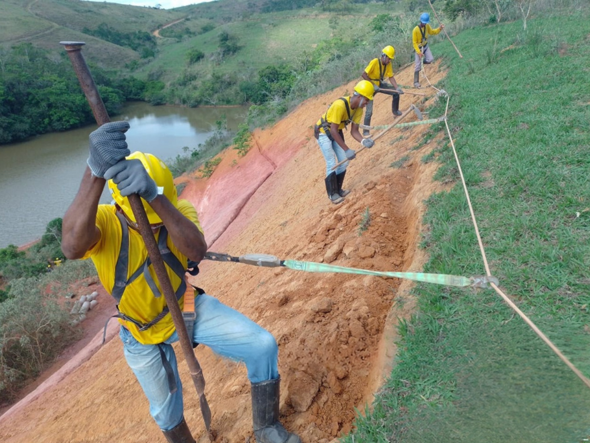 Operação de hidrossemeadura em talude de terra vermelha