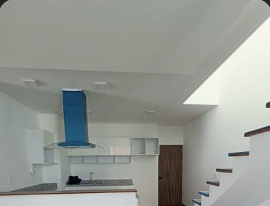 Departamento con cocina abierta y campana de diseño azul