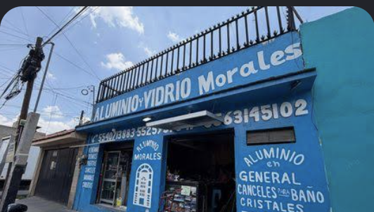 Local de dos niveles con fachada azul sobre avenida
