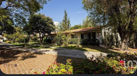 Casa de un nivel con teja y amplio jardín arbolado