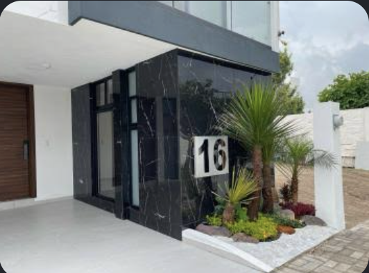 Casa de diseño con fachada de mármol negro y balcón de cristal