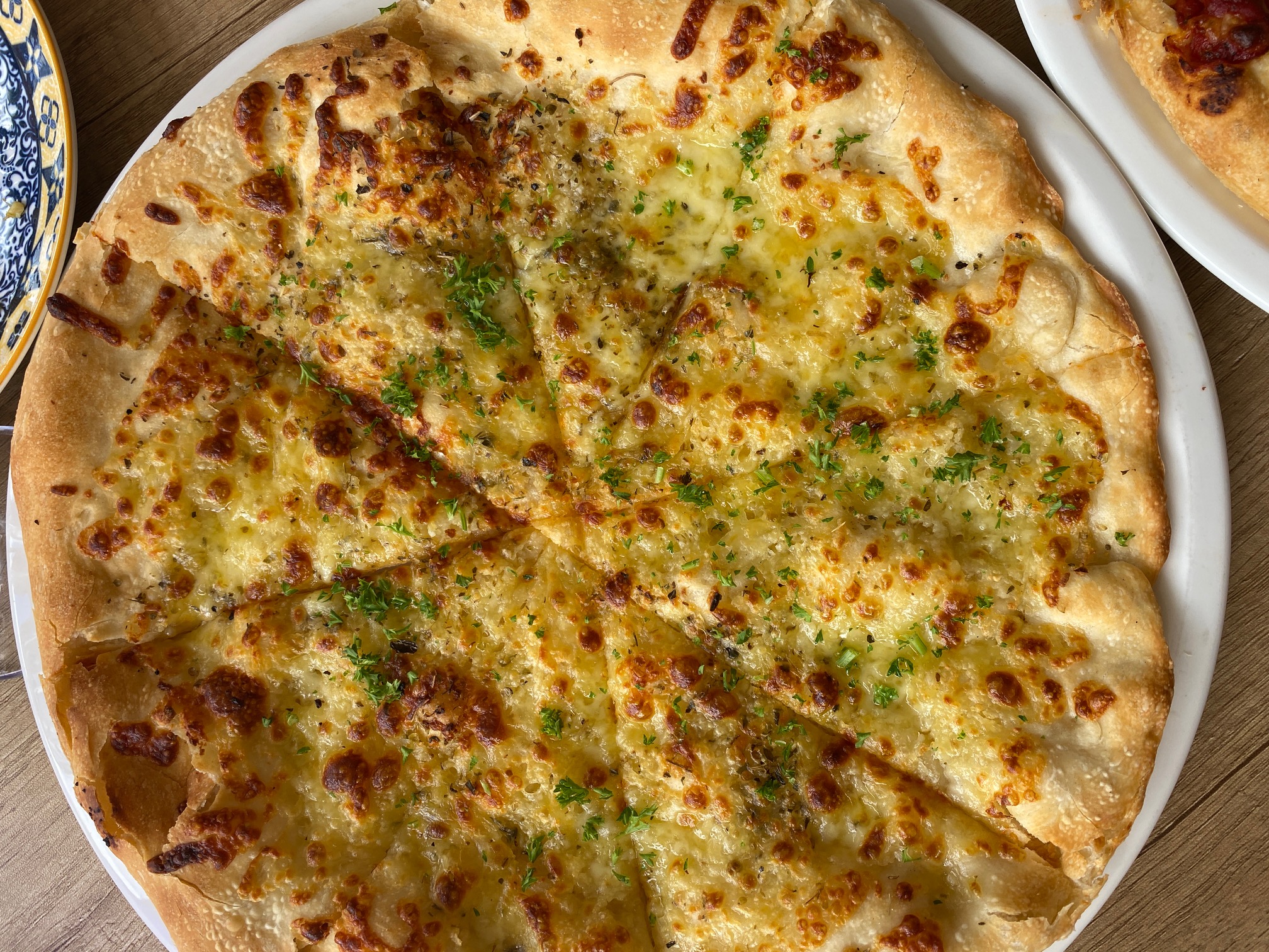 Garlic pizza bread with melted cheese and parsley