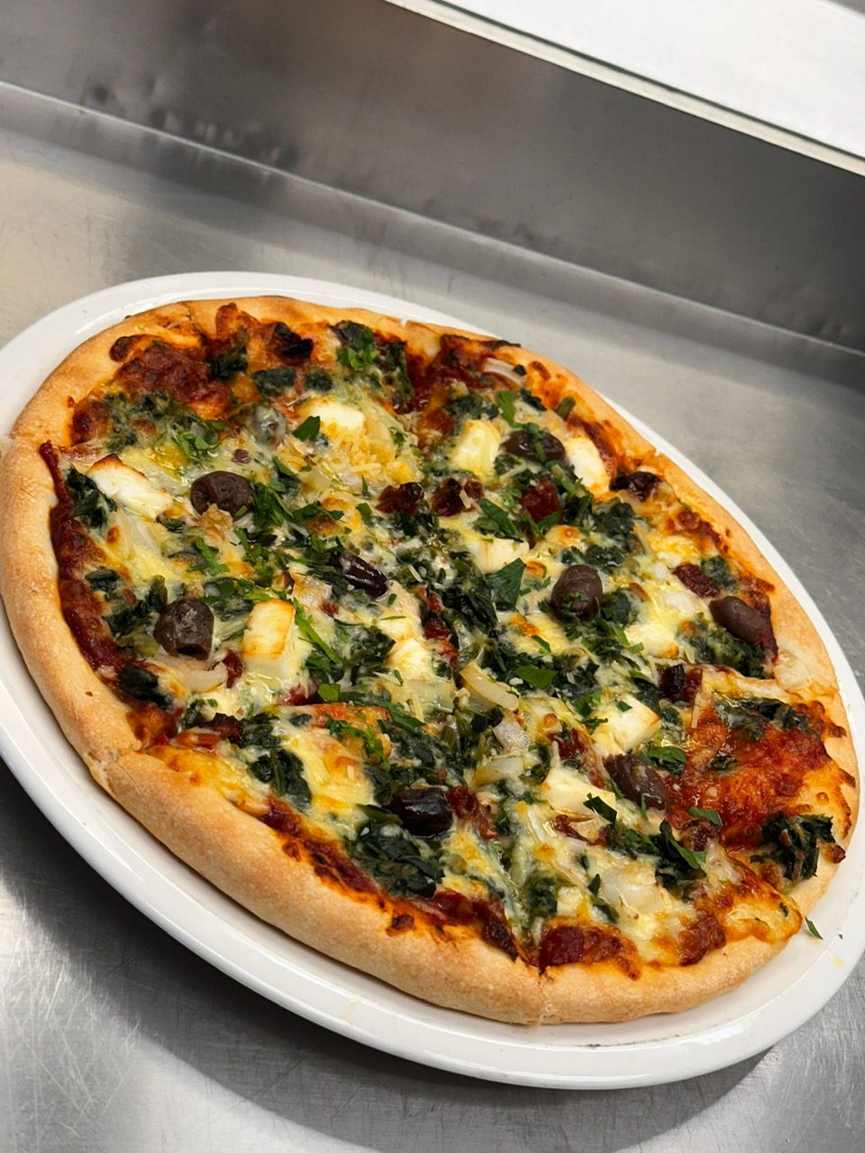 Vegetarian pizza with spinach, feta, olives and onion