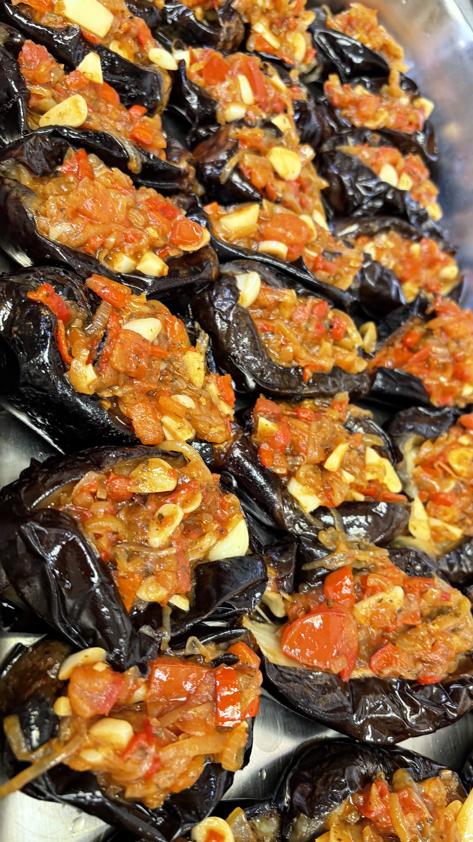 Imam Bayildi stuffed eggplant with tomatoes, onions and garlic in a catering tray