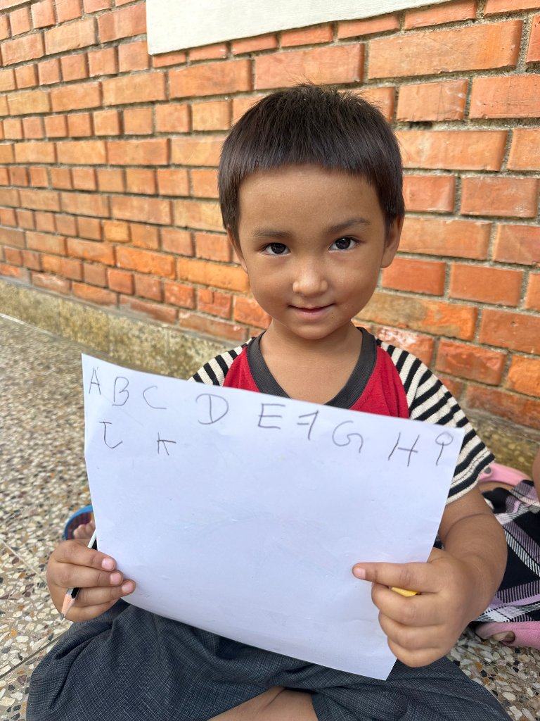 Child holding alphabet paper