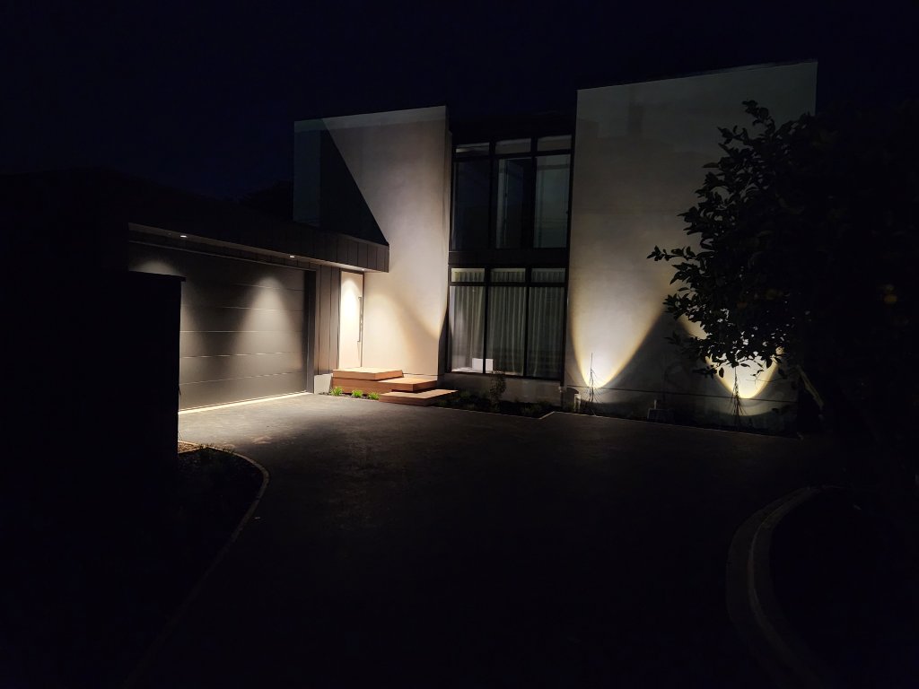 Modern architectural home with exterior uplighting at night