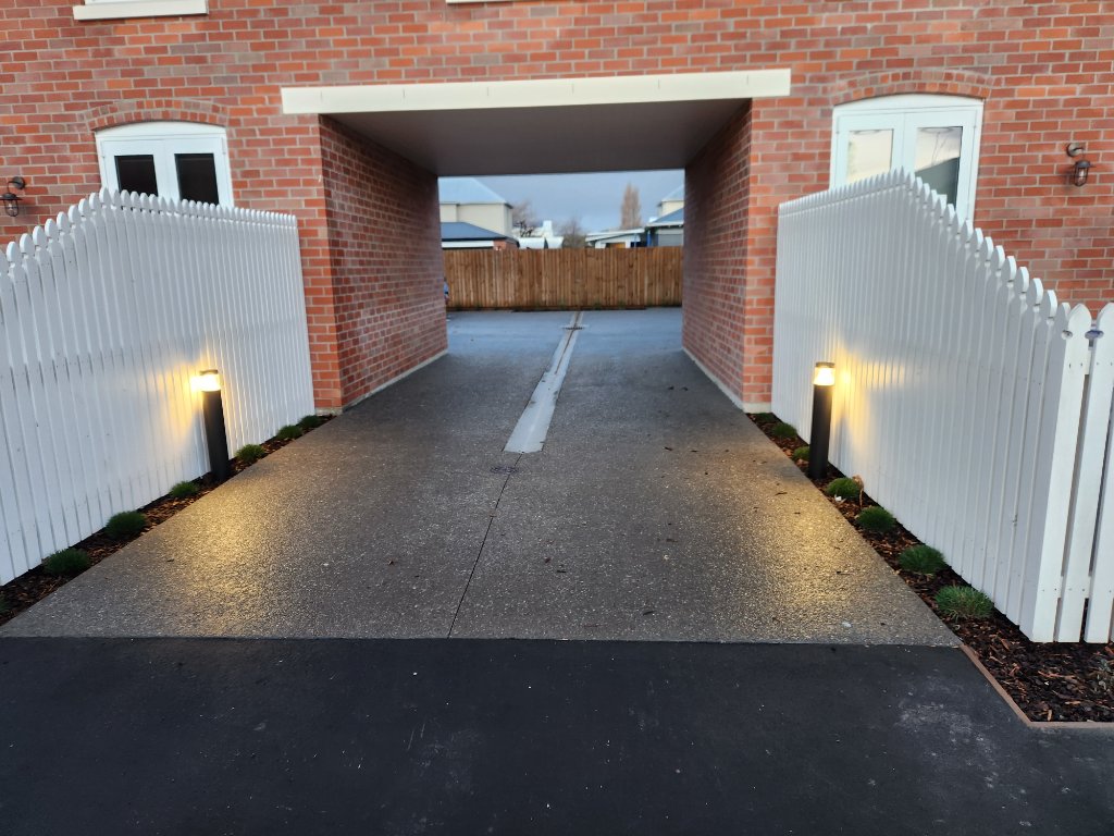Brick archway with picket fence and bollard lighting