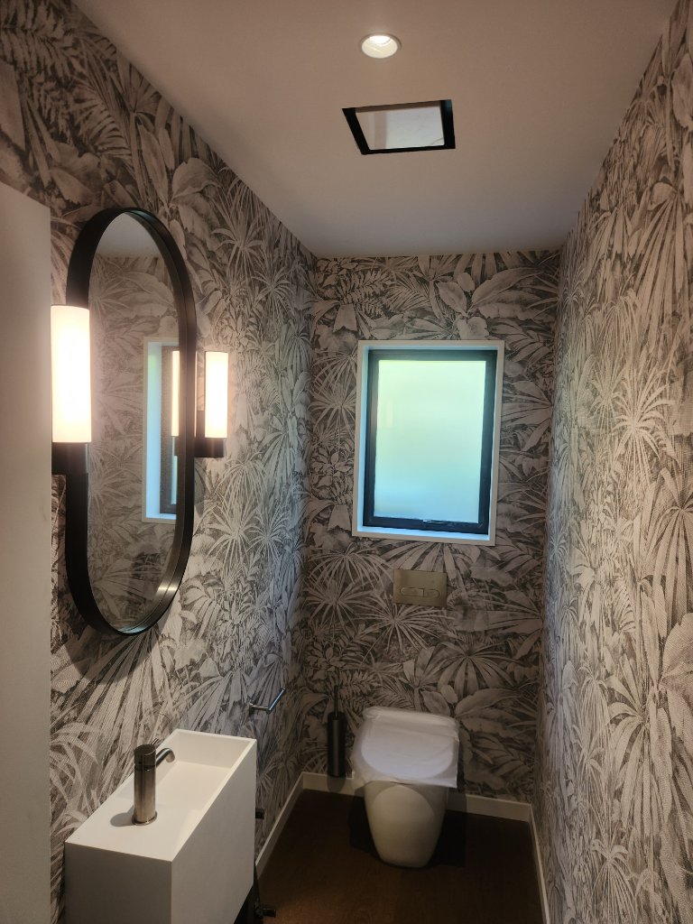 Powder room with feature wallpaper and wall lighting