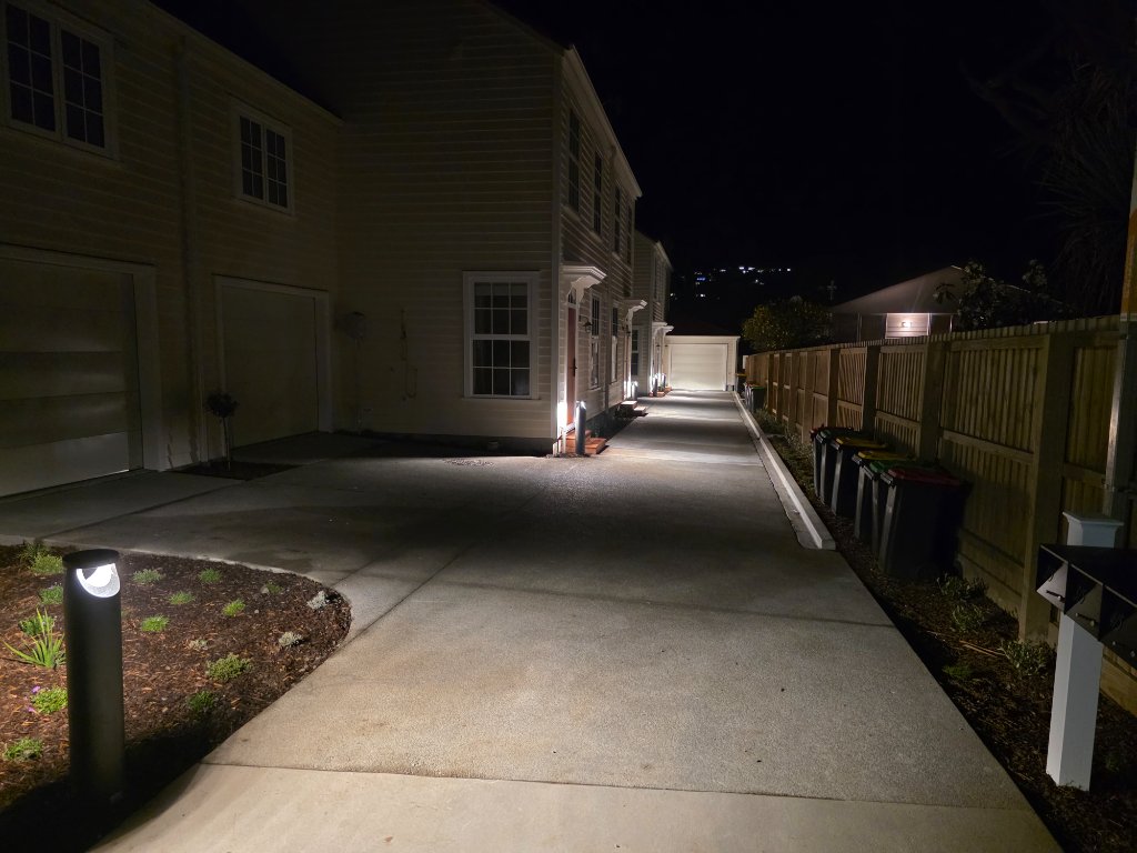 Townhouse driveway with exterior lighting at night