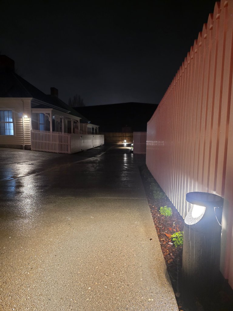 Fenced pathway with bollard lighting at night