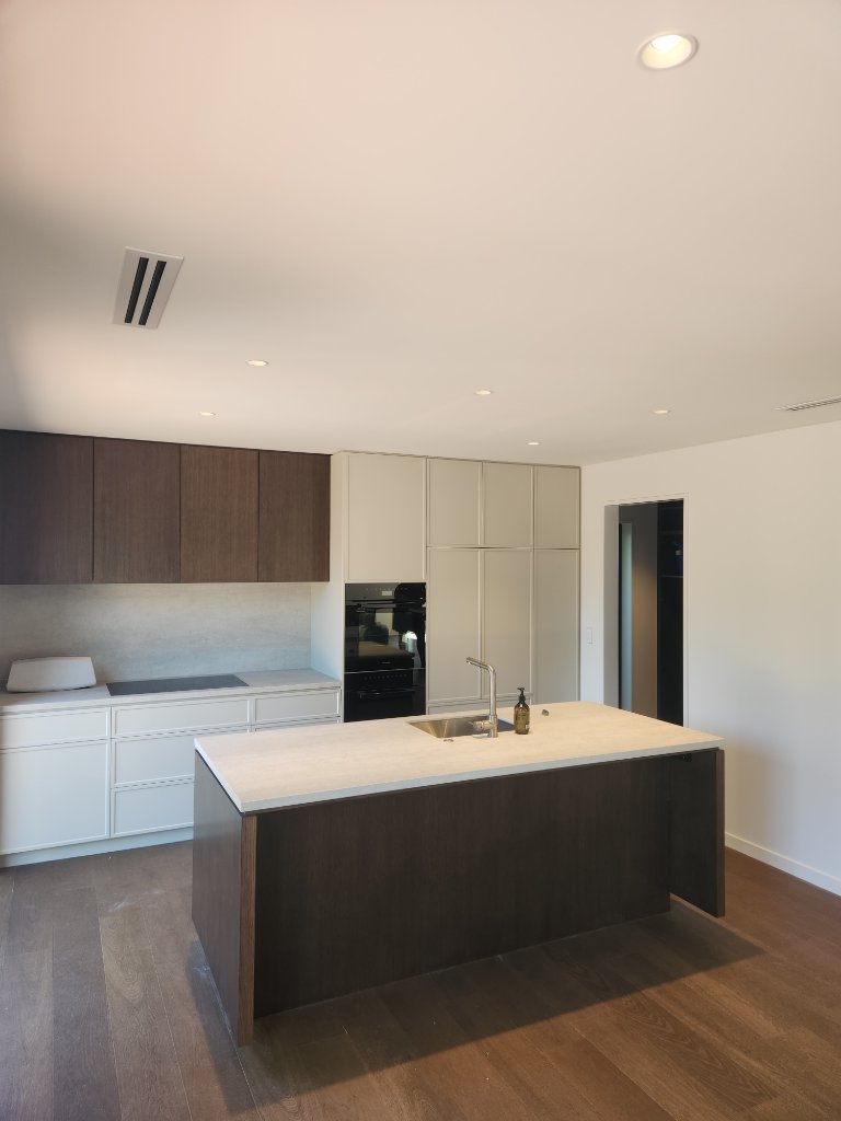 Modern kitchen with dark island and recessed lighting
