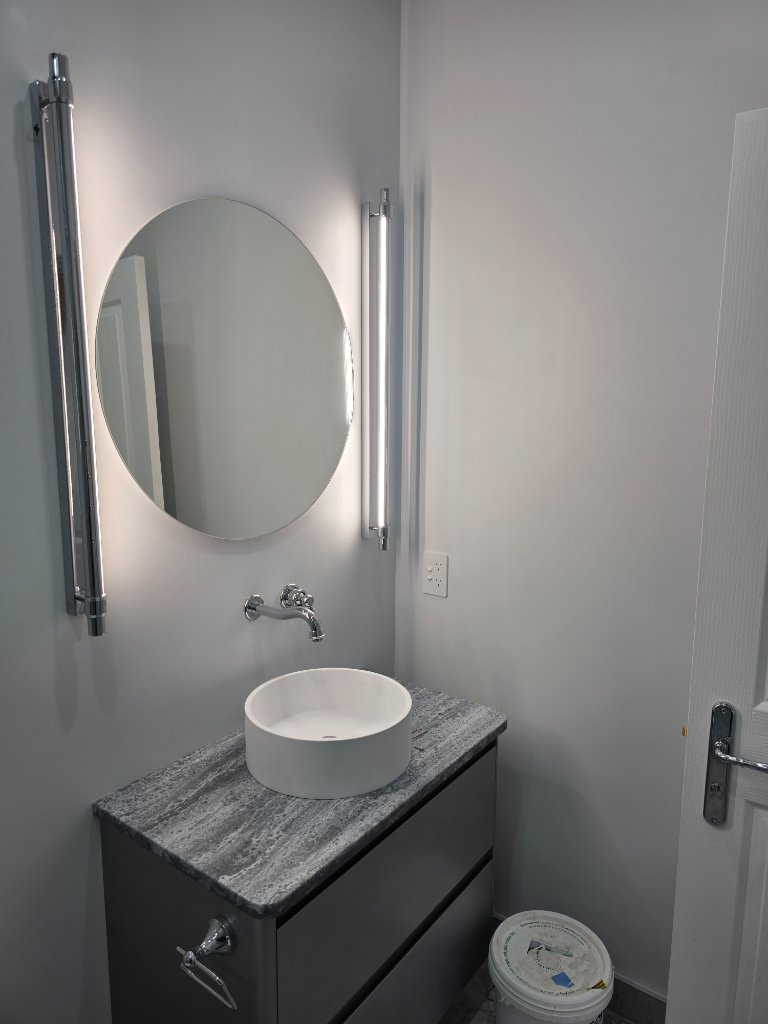 Bathroom vanity with round mirror and LED wall lights