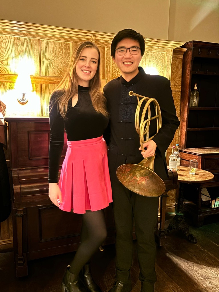 Two performers with a natural horn posing after a Tinklings concert