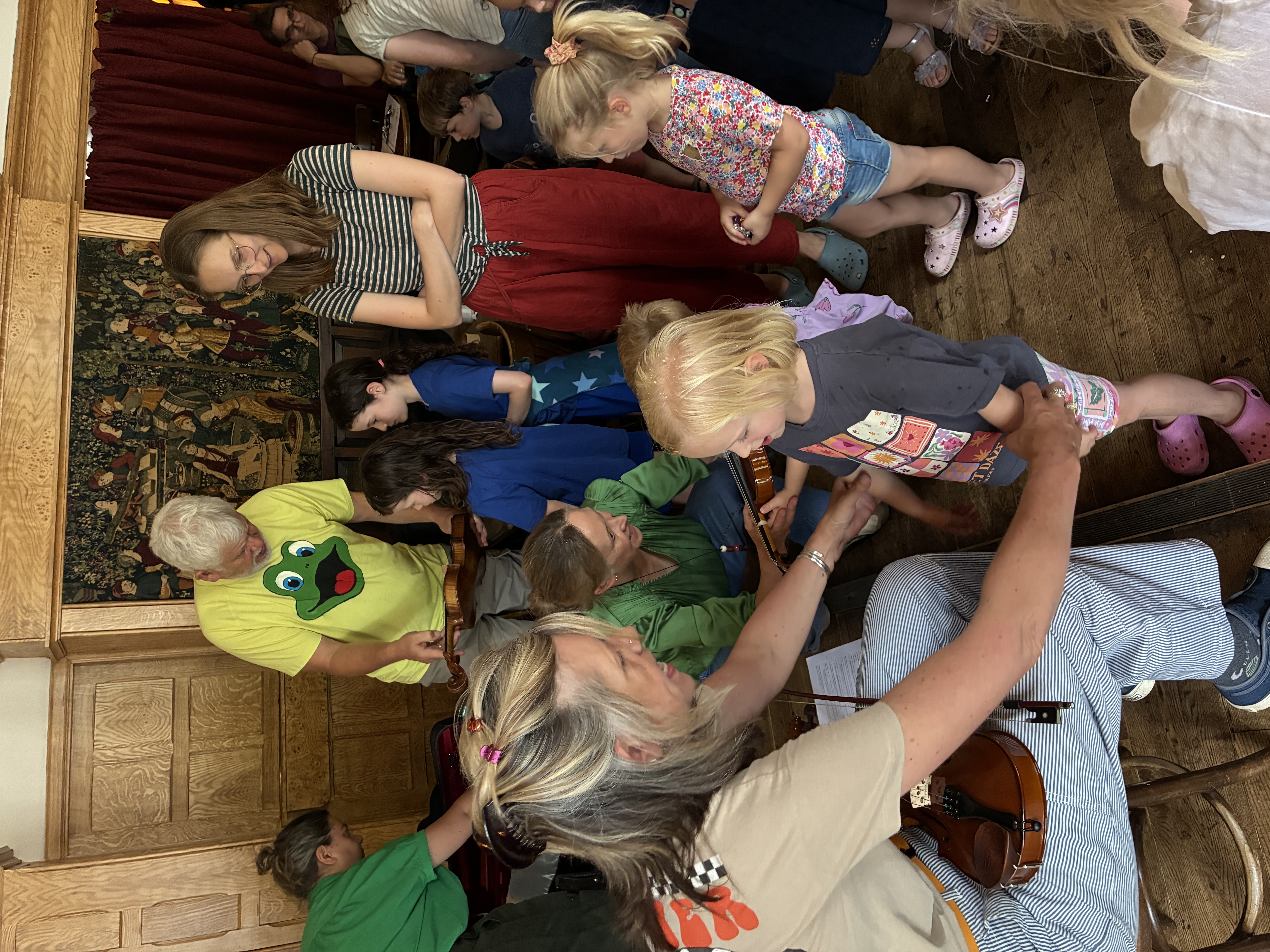Musicians and children exploring violins together at a Tinklings workshop