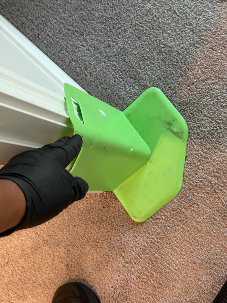 HydroLux technician using corner guard protector during carpet cleaning to protect baseboards