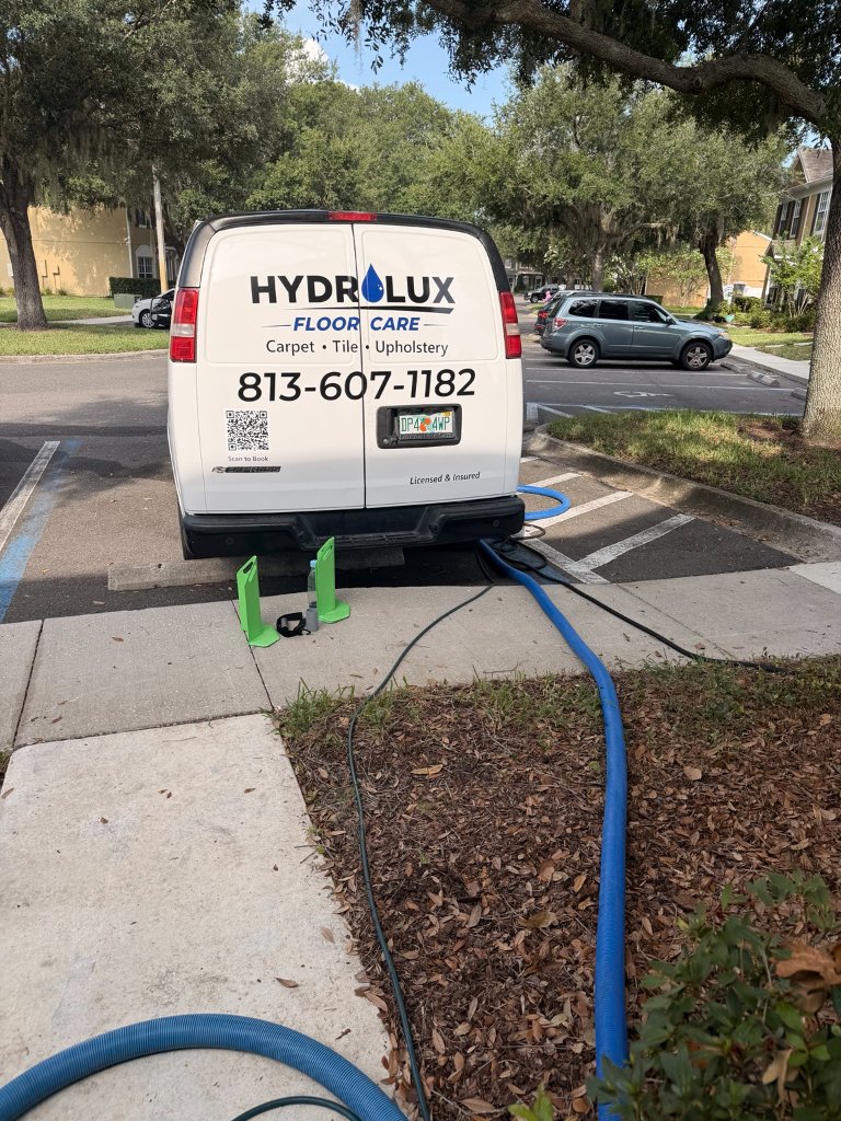 HydroLux Floor Care branded van parked outside residential home showing phone number 813-607-1182