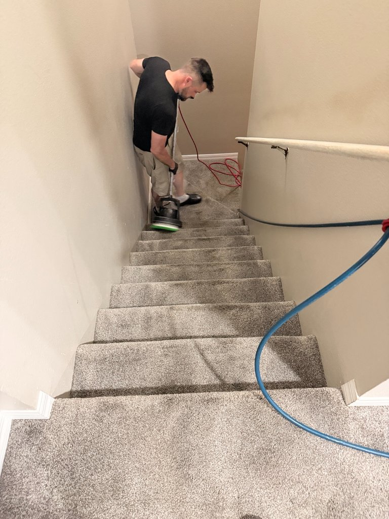HydroLux technician using rotary scrubber to deep clean carpeted stairs in residential home
