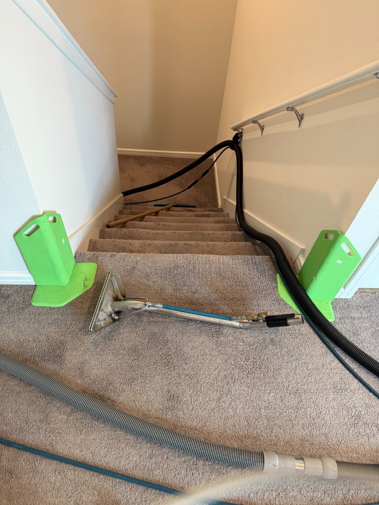 HydroLux carpet cleaning equipment set up at base of residential staircase