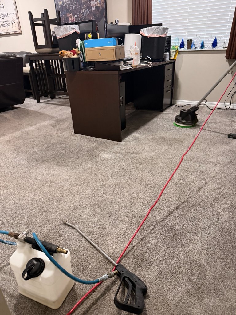 Carpet cleaning in progress in home office using rotary extraction tool and sprayer