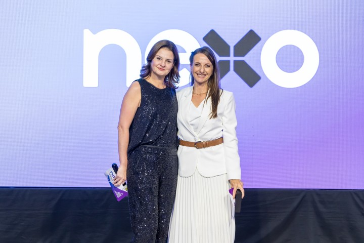 Duas mulheres no palco com tela LED do NEXO ao fundo