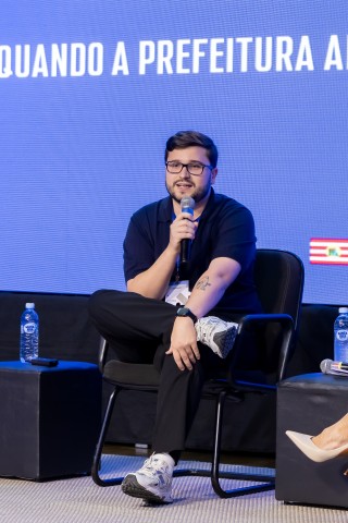 Palestrante sentado no palco do NEXO 2026