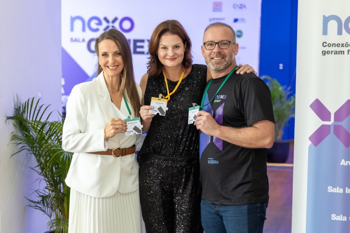 Participantes posando com crachás no NEXO 2026