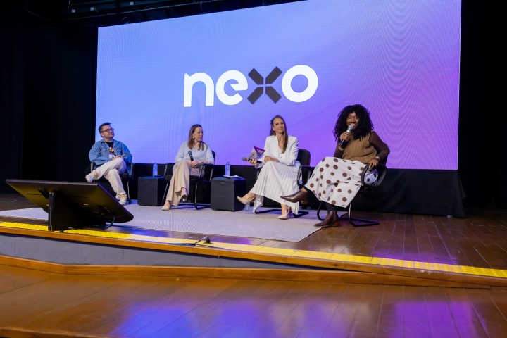Painel com quatro palestrantes no palco do NEXO 2026