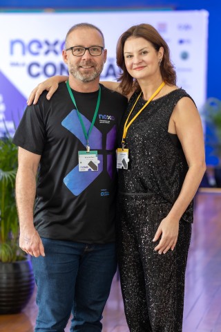 Casal de participantes posando no NEXO 2026