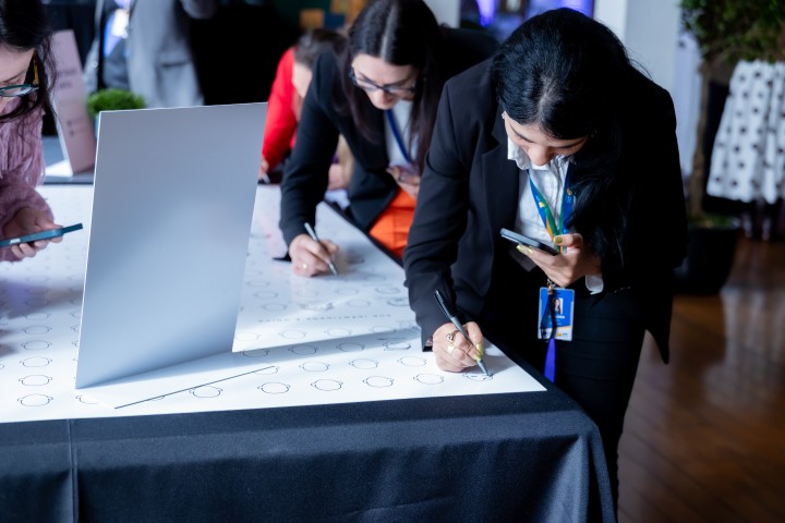 Participantes escrevendo no mural do NEXO 2026