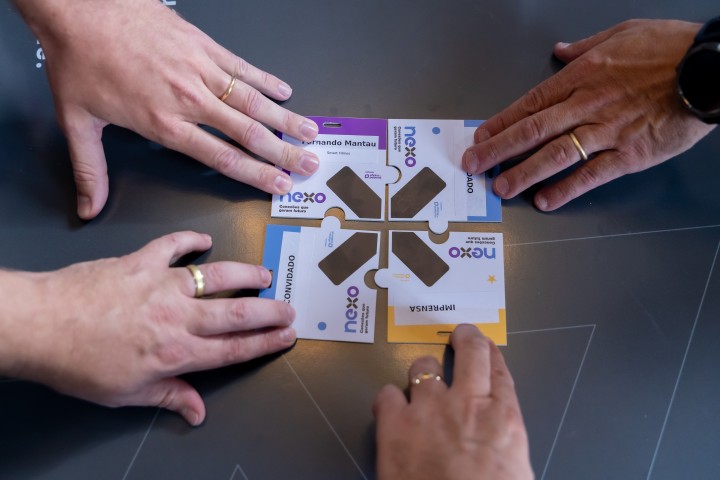 Mãos montando peças de quebra-cabeça NEXO